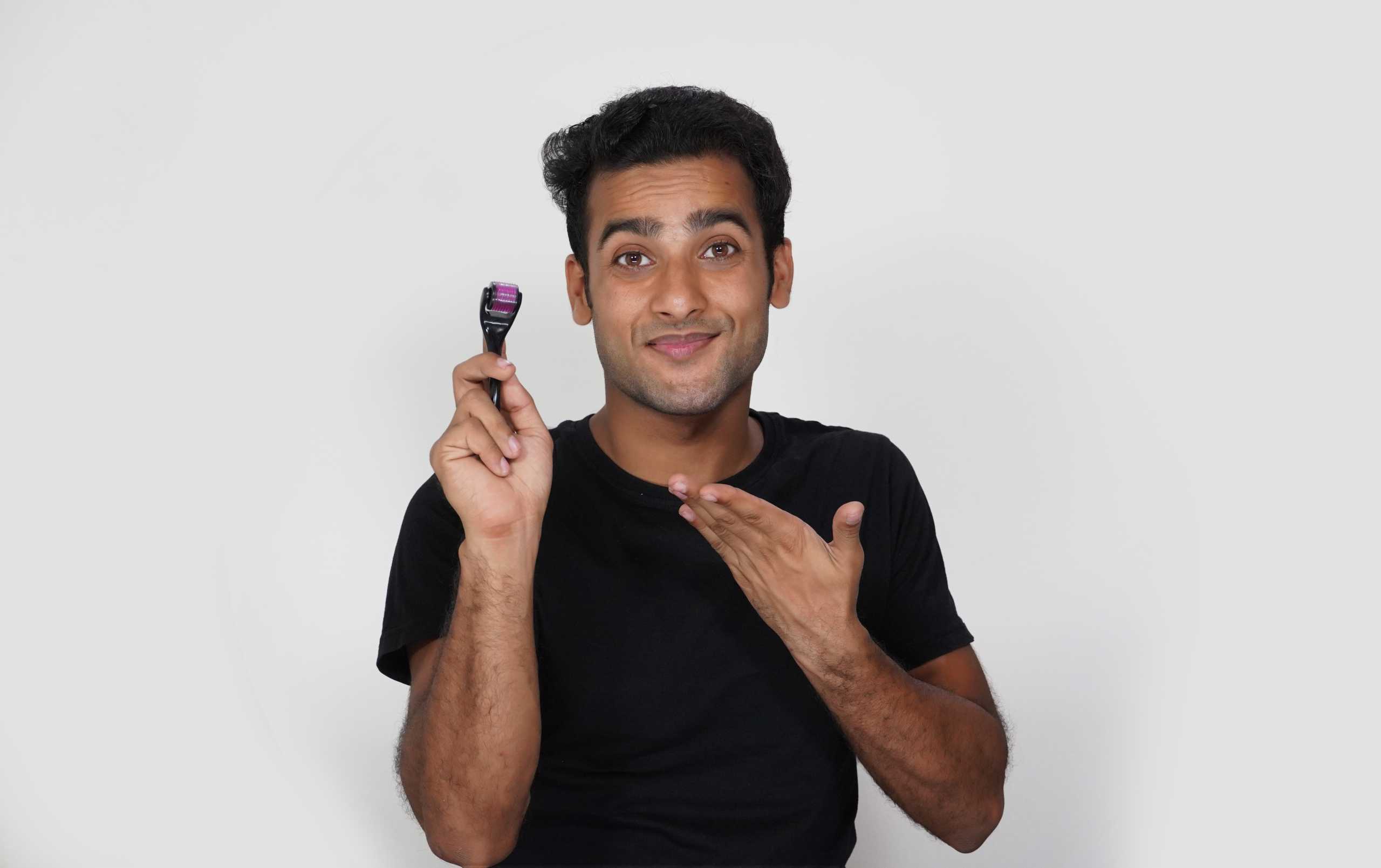 A man having using derma roller and he is happy and exited for hair growth